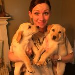 woman holding two puppies