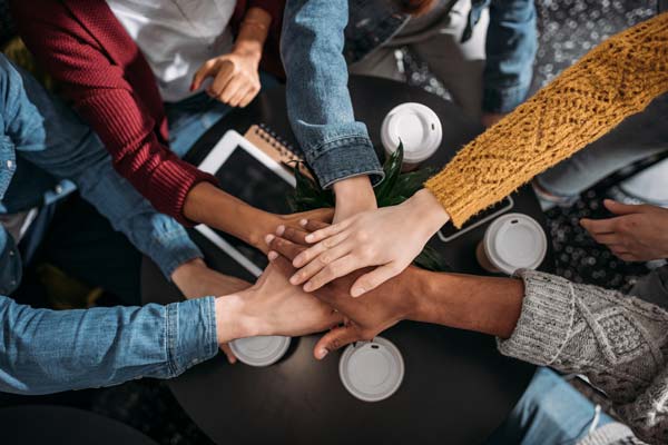 Stacked hands meeting in center